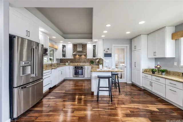 a kitchen with stainless steel appliances granite countertop a refrigerator stove microwave and cabinets