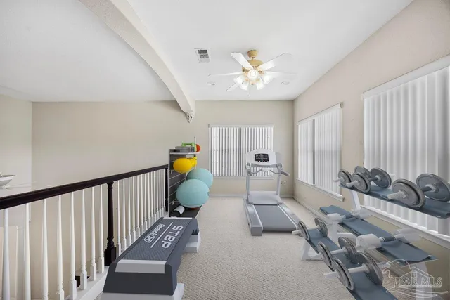 a view of an empty room with stairs and a window