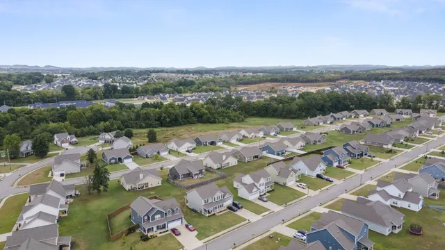 a aerial view of a house next to a big yard and large trees