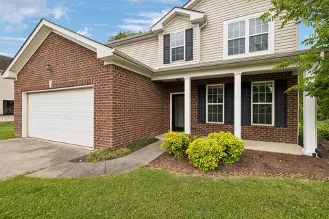 a front view of a house with a garden and yard