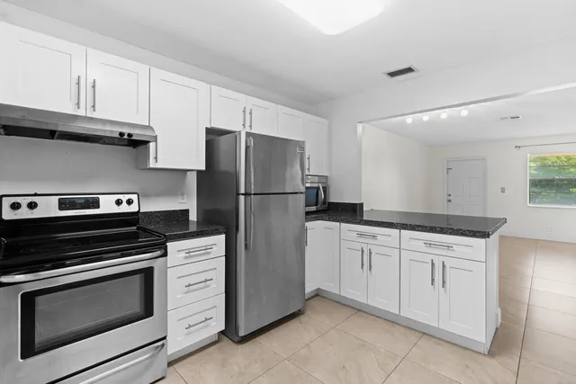 a kitchen with granite countertop cabinets and steel stainless steel appliances
