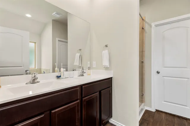 a bathroom with double vanity sinks and a mirror