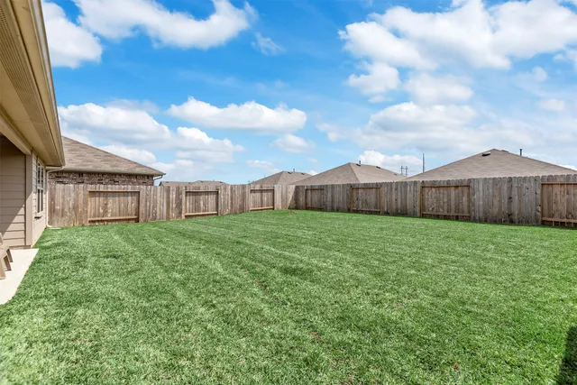 a view of a backyard with table and chairs and wooden fence