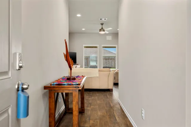 a view of hall way with furniture and wooden floor