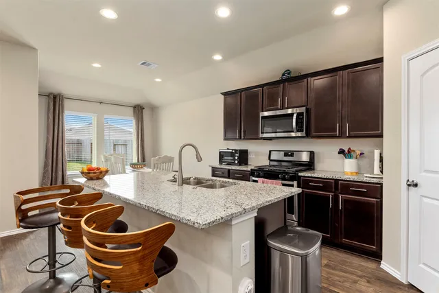 a kitchen with a sink a stove and a microwave
