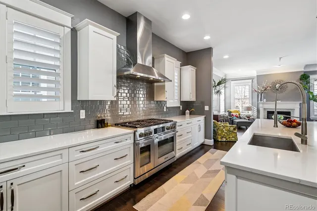 a kitchen with a sink stove and wooden floor