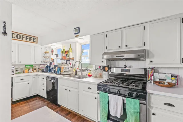 a kitchen with a stove a sink and cabinets