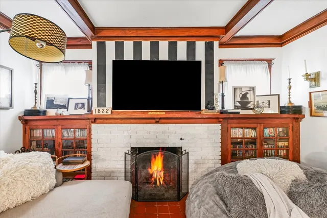 a bedroom with a bed a fireplace and dresser