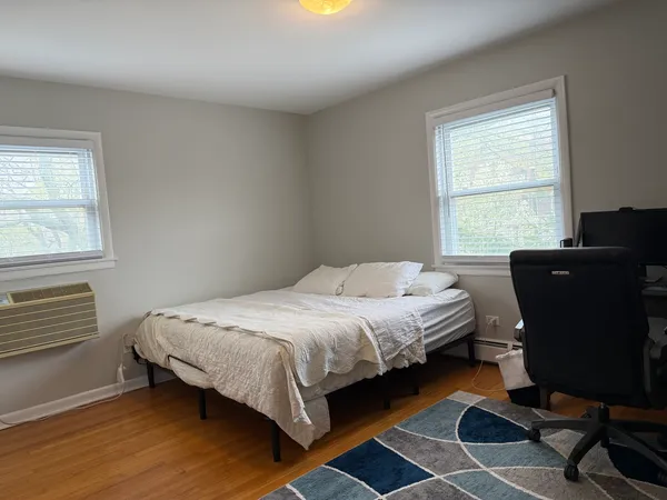 a bedroom with a bed window and chair