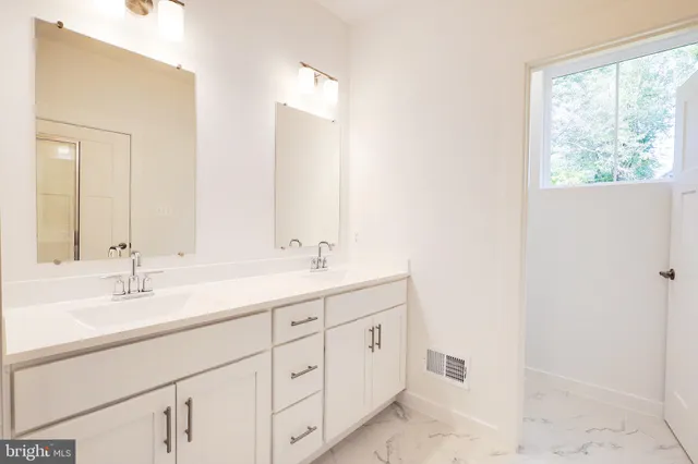 a bathroom with a sink vanity and mirror