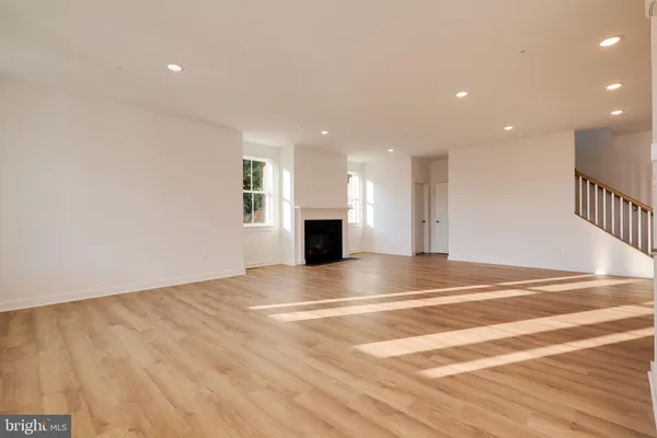 a view of empty room with wooden floor and fireplace