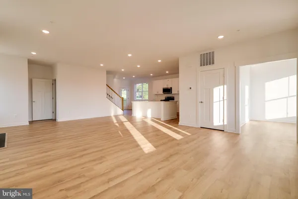 a view of empty room with wooden floor and seating area