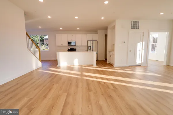 a view of kitchen with stainless steel appliances kitchen island sink and refrigerator