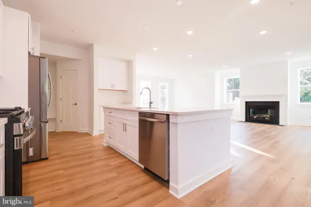 a kitchen with stainless steel appliances a stove top oven a sink and a refrigerator