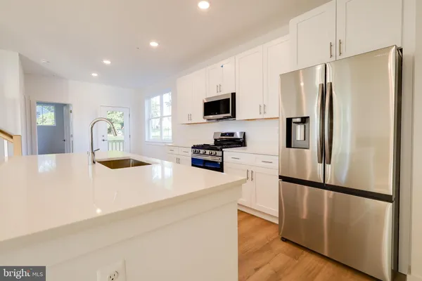 a kitchen with stainless steel appliances a refrigerator sink and microwave