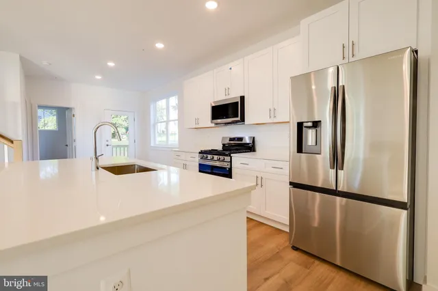 a kitchen with stainless steel appliances a refrigerator sink and microwave