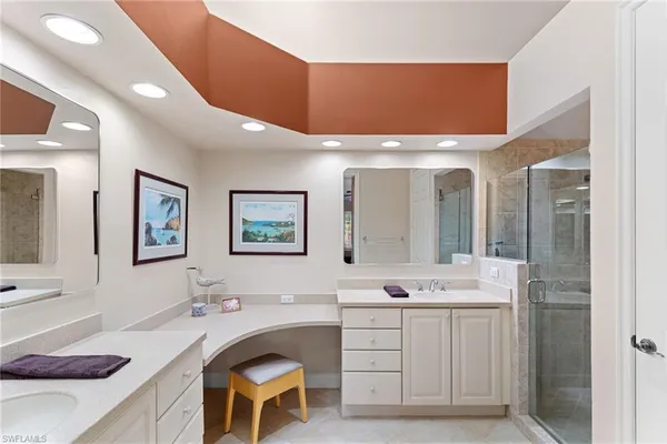 a bathroom with a double vanity sink mirror and bathtub