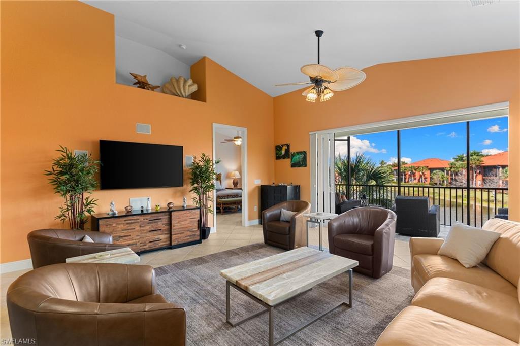 6417 Legacy Circle, Unit 1504 Naples, FL 34113 - Photo 5 of 49 a living room with furniture a ceiling fan a flat screen tv and a window