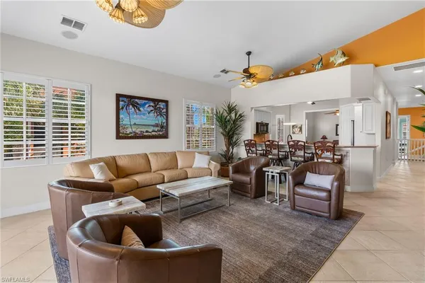 a living room with furniture kitchen view and a window