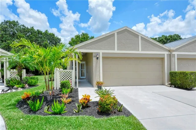 a front view of a house with a yard and potted plants
