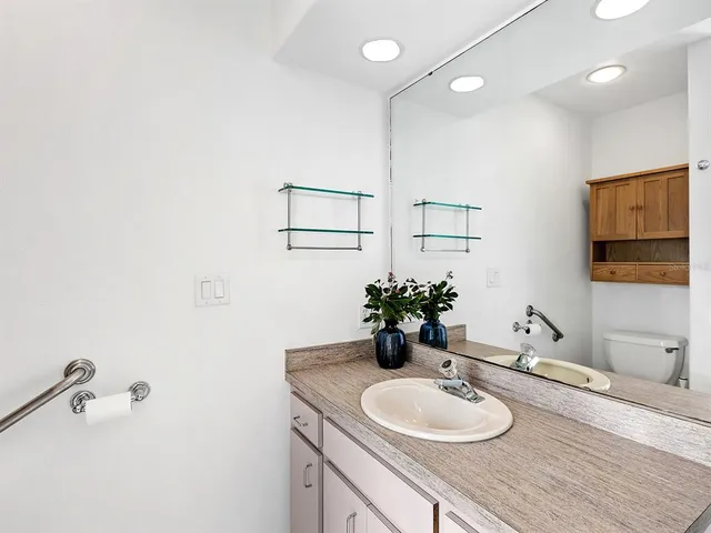 a bathroom with a granite countertop sink and a mirror