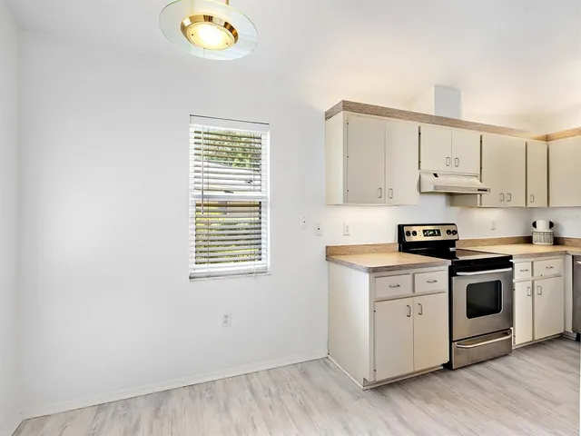 a kitchen with a stove a sink and a window