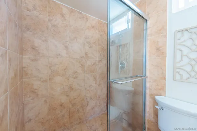 a bathroom with a granite countertop shower and a toilet