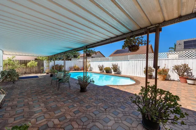 a view of a patio with table and chairs under an umbrella