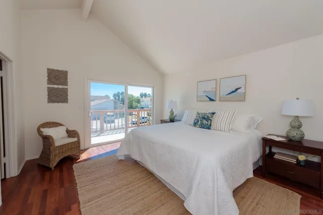 a bedroom with a bed chair and a large window