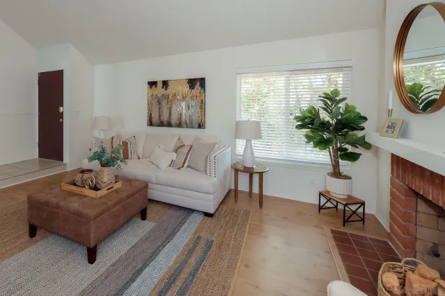 a living room with furniture a potted plant and a table