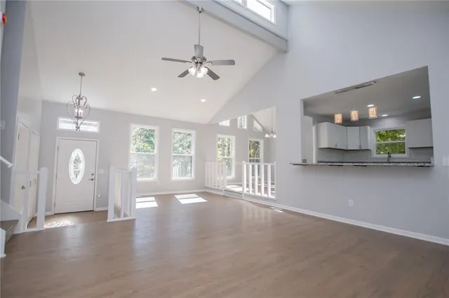 a view of an empty room with a window and wooden floor