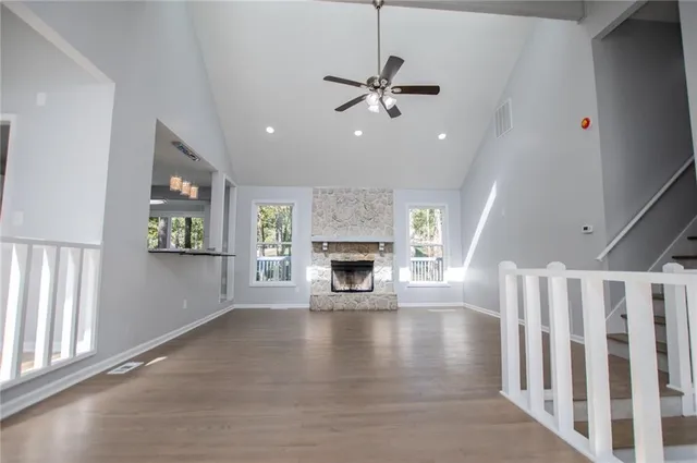 an empty room with a chandelier fan and windows
