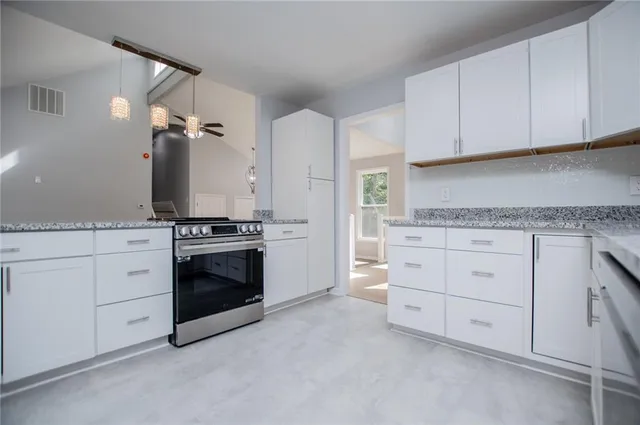 an empty room with closet and a chandelier fan