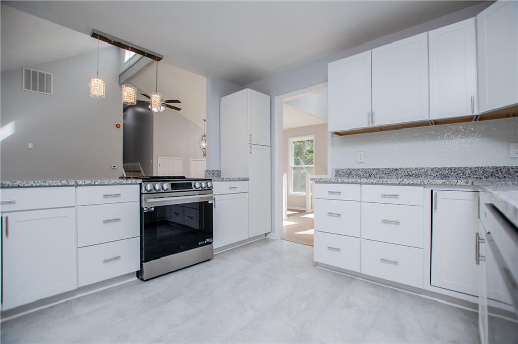 1039 Monticello Drive Villa Rica, GA 30180 - Photo 20 of 96 a kitchen with granite countertop white cabinets and stainless steel appliances