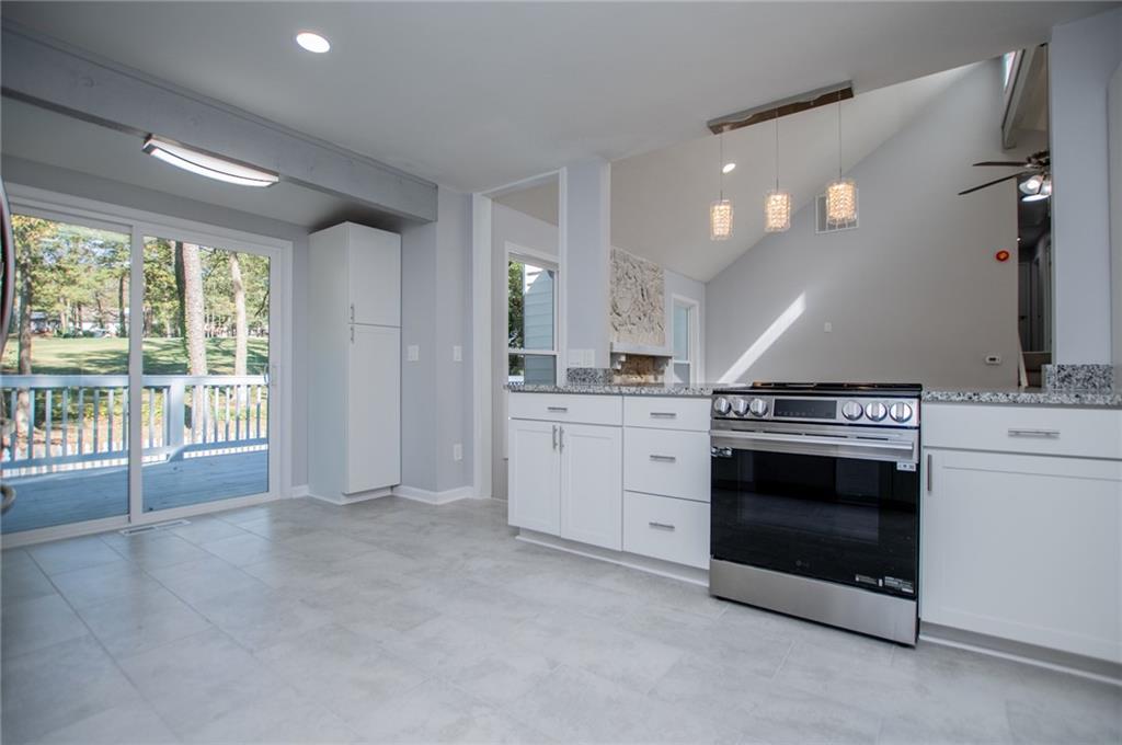 1039 Monticello Drive Villa Rica, GA 30180 - Photo 22 of 96 a view of a kitchen with a stove wooden cabinets and a large window