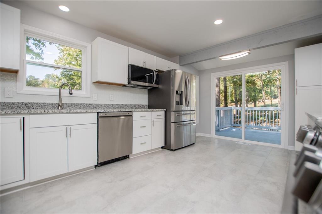 1039 Monticello Drive Villa Rica, GA 30180 - Photo 24 of 96 a kitchen with stainless steel appliances granite countertop a stove a sink dishwasher a refrigerator with white cabinets and wooden floor