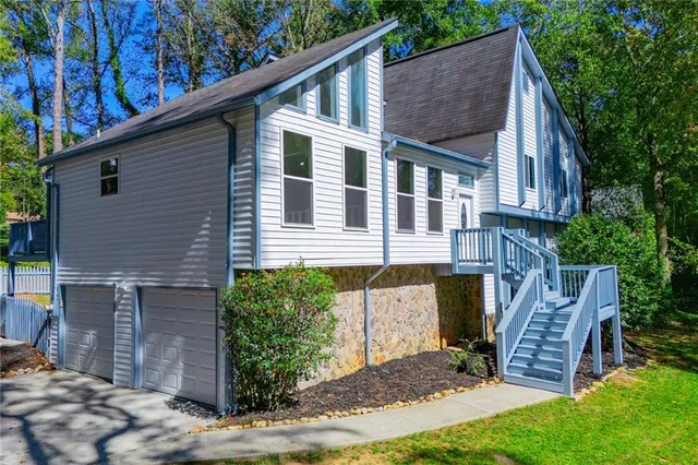a view of a house with a small yard and wooden fence