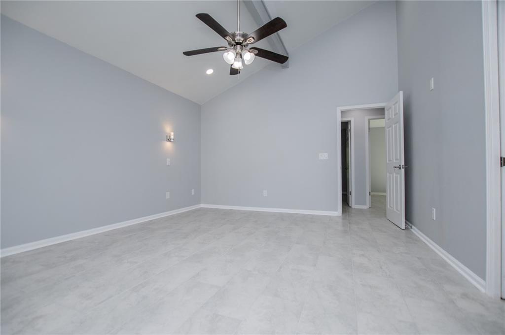 1039 Monticello Drive Villa Rica, GA 30180 - Photo 31 of 96 an empty room with a chandelier fan and windows