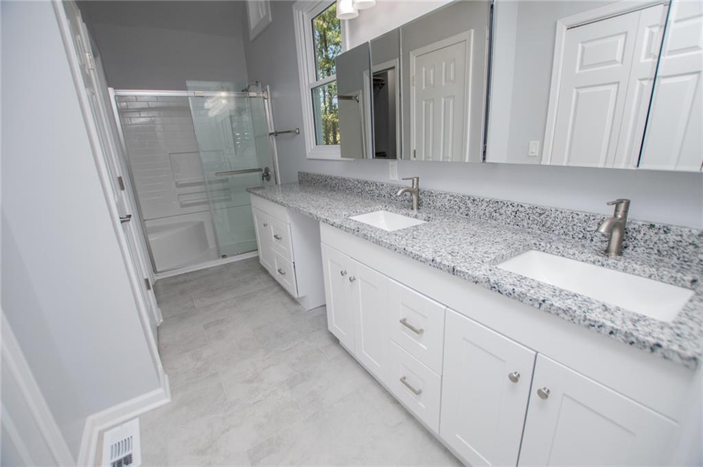 1039 Monticello Drive Villa Rica, GA 30180 - Photo 32 of 96 a bathroom with a granite countertop sink and a mirror