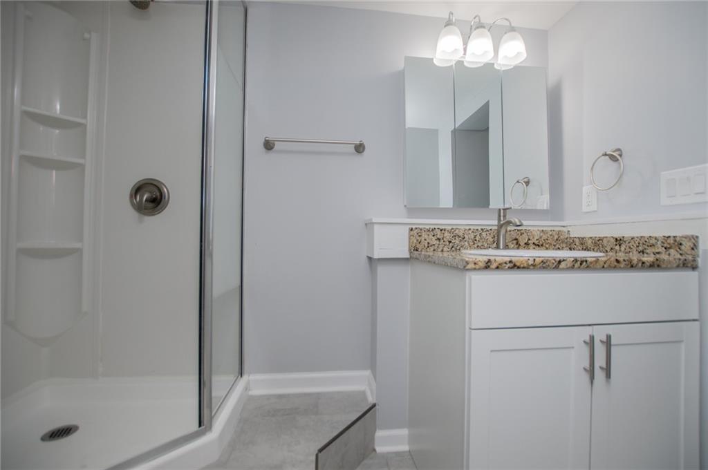 1039 Monticello Drive Villa Rica, GA 30180 - Photo 60 of 96 a bathroom with a granite countertop shower a mirror and a sink