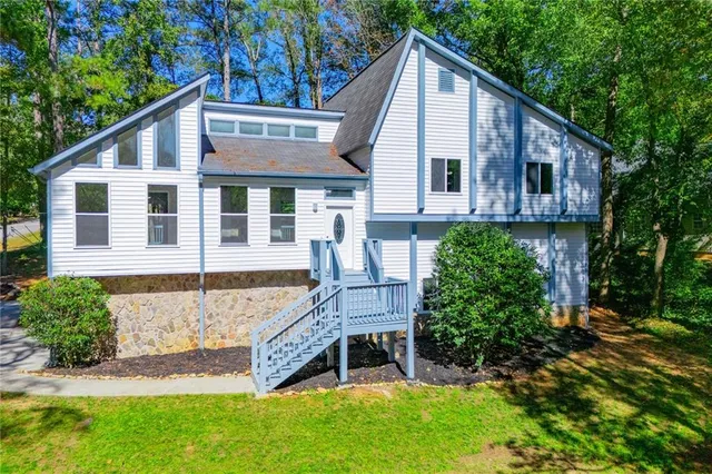 a view of an empty room with wooden floor fireplace and a window
