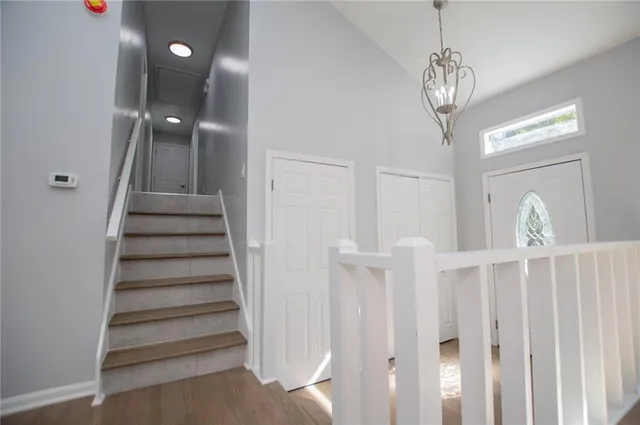 a kitchen with stainless steel appliances granite countertop a stove a sink dishwasher a refrigerator with white cabinets and wooden floor