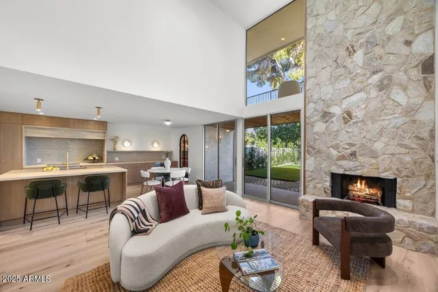 a living room with furniture a fireplace a rug and a window