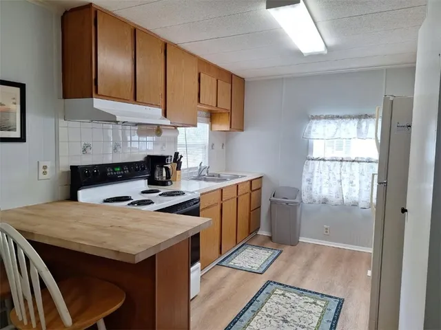a kitchen with a stove a sink a refrigerator and cabinets