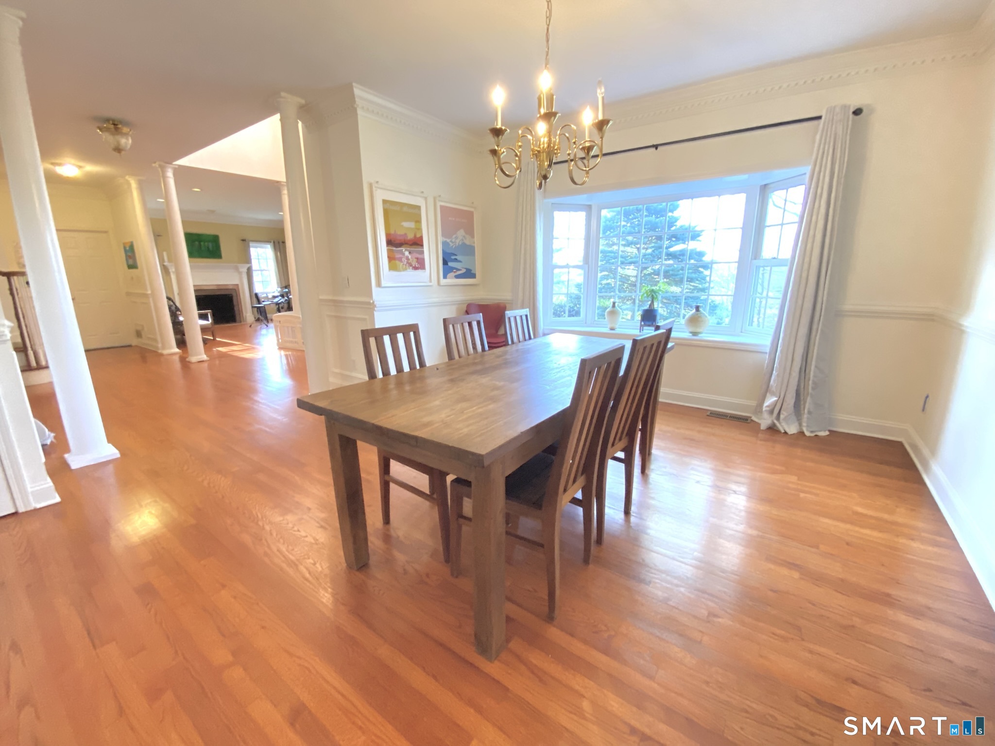 12 Carriage Hill Road Woodbridge, CT 06525 - Photo 12 of 24 a dining room with wooden floor a chandelier a wooden table and chairs