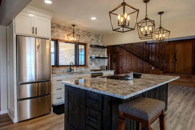 a kitchen with stainless steel appliances granite countertop a stove a sink and a wooden floors