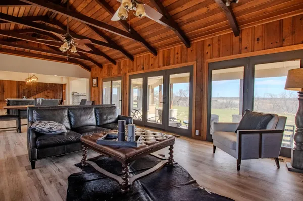 a living room with furniture a wooden floor and a floor to ceiling window