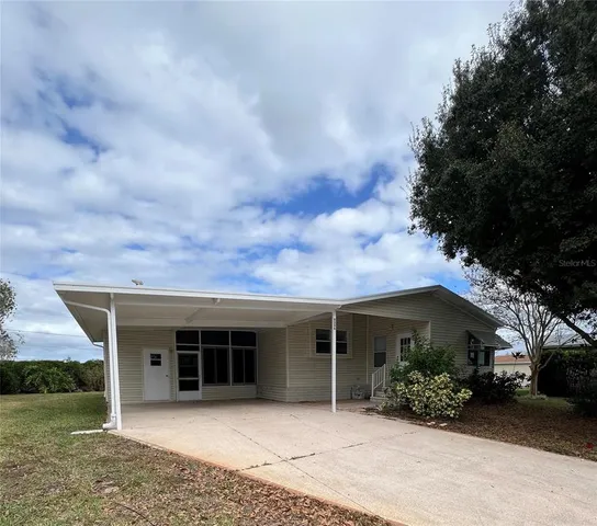 front view of a house with a yard and potted plants