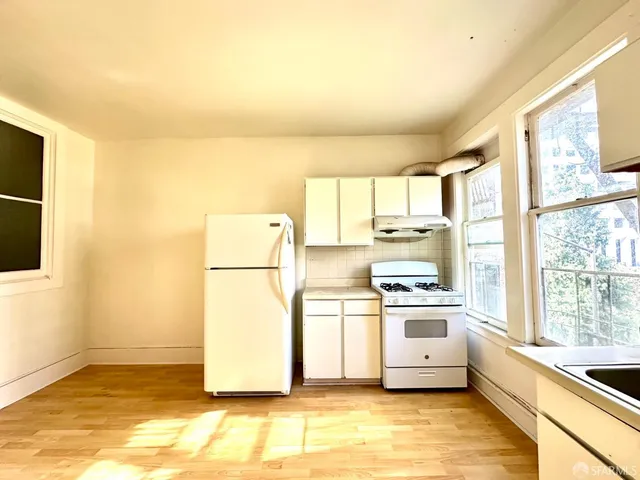 a view of a big room with wooden floor and a window