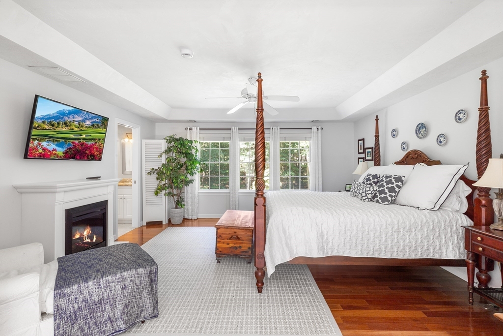28 Broken Tree Road Medway, MA 02053 - Photo 23 of 42 a bedroom with a large bed couch and a fireplace